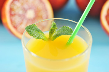 orange juice in glass with mint and a straw