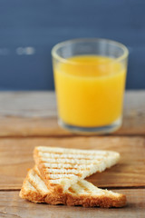 two toast bread closeup on a background of a glass of orange juice