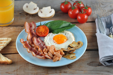 Breakfast of eggs with bacon, beans, mushrooms, tomatoes and spinach