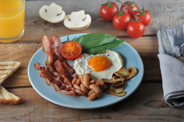 Breakfast of eggs with bacon, beans, mushrooms, tomatoes and spinach