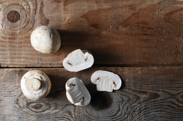 Fresh white mushrooms champignon on rustic wooden background