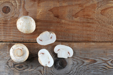 Fresh white mushrooms champignon on rustic wooden background