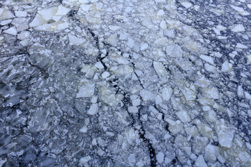 Broken ice on the surface of the river in winter. Ice floes texture