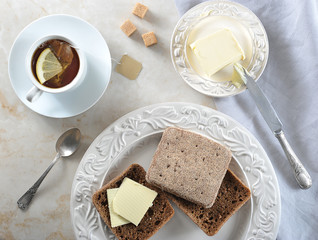 simple Breakfast - tea bags with lemon and rye bread with butte