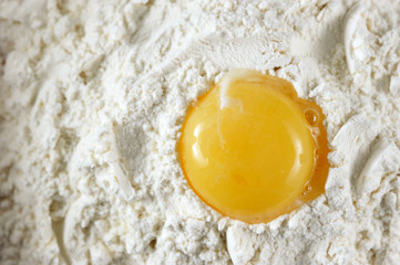 raw egg yolk in the flour - top view