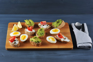 canape sandwiches on a wooden Board