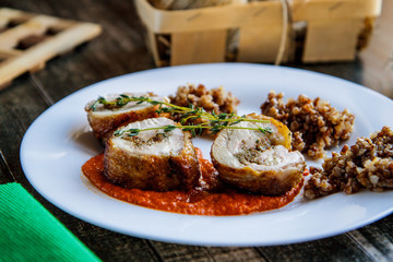 Pieces of chicken roll and buckwheat on a ceramic plate side view
