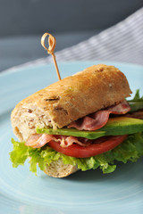 sandwich with bacon and avocado pierced with a skewer