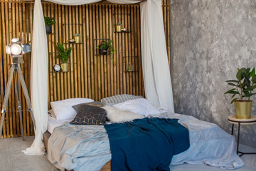 Bed in the loft style. The wall of wooden rails. Interior in Loft style
