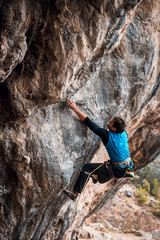 Men climbs a rock with a rope, lead, in cold weather. Hard pitches. Chitdibi, Turkey