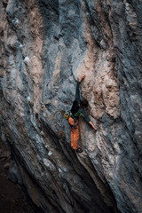 Men climbs a rock, 7c pitch with a rope, lead. Chitdibi, Turkey