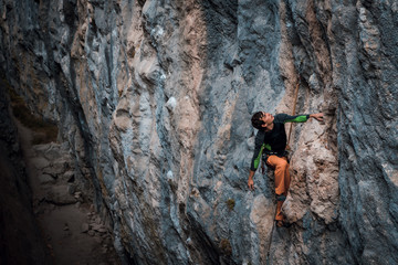 Men climbs a rock, 7c pitch with a rope, lead. Chitdibi, Turkey