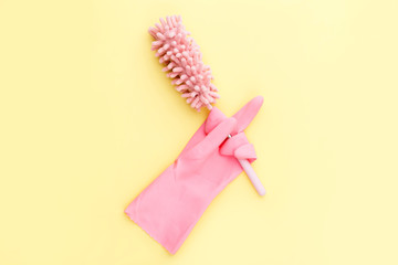 humorous cleaning concept, soft brush for dust in rubber gloves shows middle finger, fucking on...