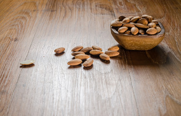 almond from wooden bowl on wooden board