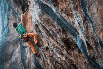 Fototapeta premium Men climbs a rock, 7c pitch with a rope, lead. Chitdibi, Turkey
