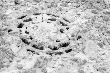 manhole sewage hatch of rain gutter ditches filled with snow after a snowstorm clogged with winter...