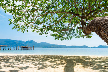 Summer vacation concept. Wooden bridge used as pier at island along the sea on sunny day.