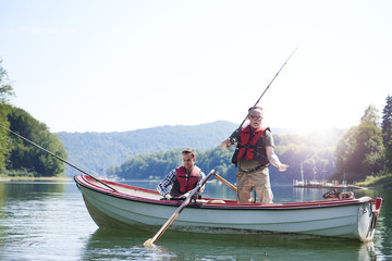 Senior man with son fishing in lake