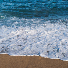 Sea ocean beach. Blue water with foam and footprints