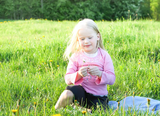 Fototapeta premium Cute little girl on the meadow in summer day