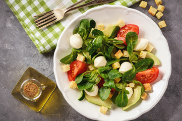 Salad with avocado, tomatoes, mozarrela and croutons.