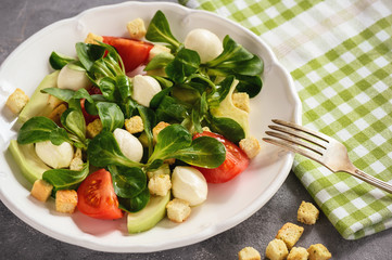 Salad with avocado, tomatoes, mozarrela and croutons.
