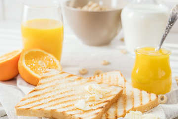 Delicious breakfast, french toasts with butter and honey, fresh oranges and juice.