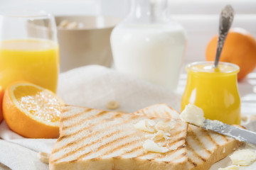 Delicious breakfast, french toasts with butter and honey, fresh oranges and juice.