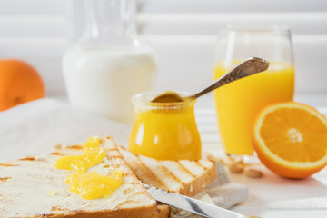 Delicious breakfast, french toasts with butter and honey, fresh oranges and juice.
