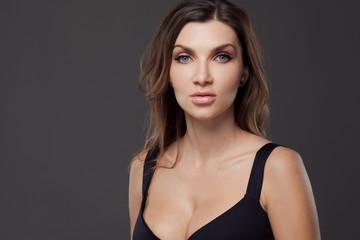 Fototapeta premium Beautiful sexy brunette woman. Portrait on gray background