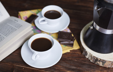 Defocused homemade cup of coffee and book .