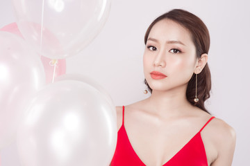 Asian beautiful woman in red dress with pastel balloons