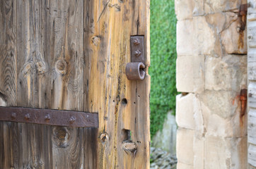 Ajar old heavy wooden door of an old castle