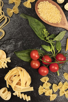 Overhead photo of different types of pasta on black