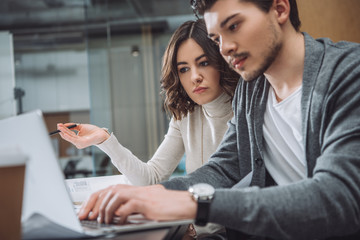 business partners working with laptop together at office