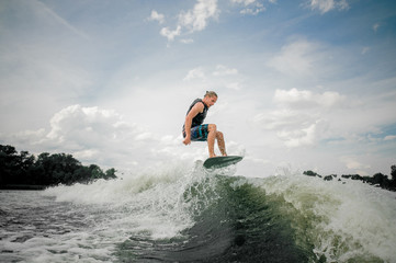 Wakesurf rider jumping on the waves of a river