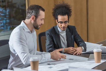 successful architects discussing building plans at office