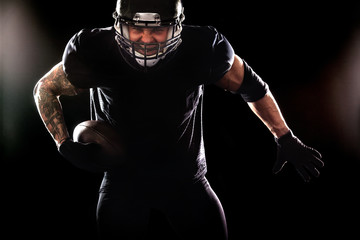 Fototapeta na wymiar American football sportsman player isolated on black background