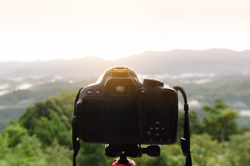 DSLR Camera set on camera tripod for take a landscape photo in selective focus.