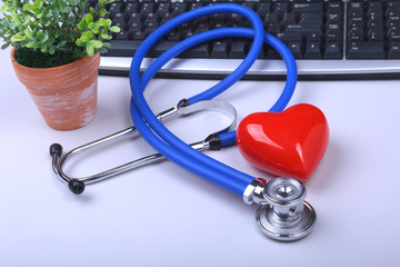 Stethoscope on modern laptop computer. red heart on white table with space for text. Healthcare...