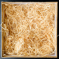 Composition with decorative straw in a box, close-up. Top view, flat lay