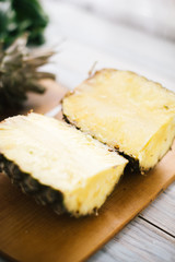 Sliced fresh pineapple on a wooden background in sunlight