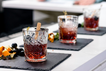 Line of classic alcoholic Godfather cocktails in rocks glasses at a bar