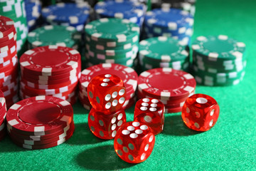 Chips and dices on green table in casino