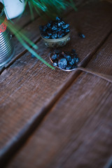 Still life of grapes and prunes on a wooden background.