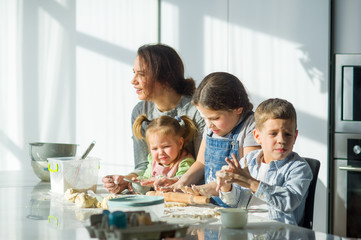 Mother teaches her three children to cook.