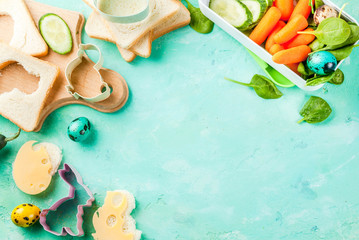 Cooking creative kids breakfast lunch box for Easter, sandwiches with cheese, fresh vegetables -...