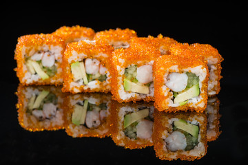 Traditional Japanese cuisine. Tasty sushi rolls with rice, cream cheese, shrimps, avocado on dark background