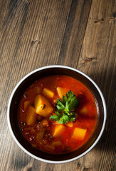 Bean and vegetables soup in ceramic bowl on wooden table
