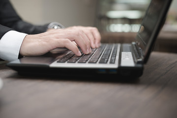 Young Asian businessman working with a laptop in a coffee shop.